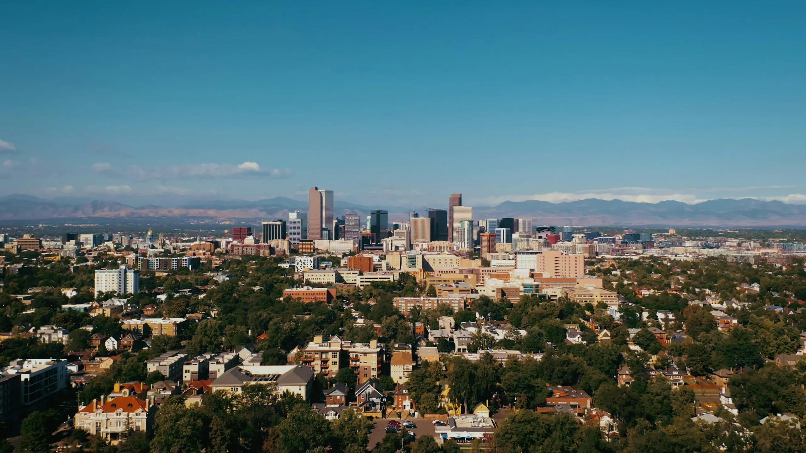 Denver, Colorado skyline with the Front Range mountains behind residential neighborhoods