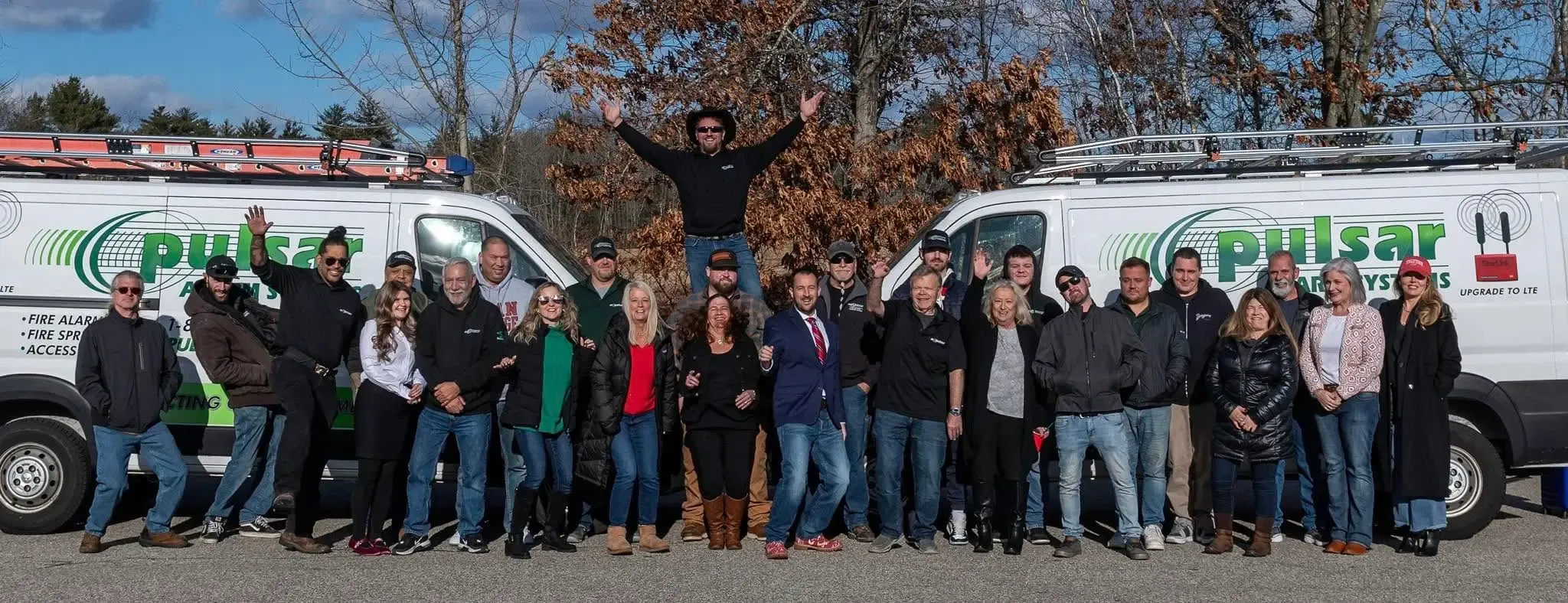 The Pulsar Alarm Systems team in front of two Pulsar vans in Plaistow, New Hampshire